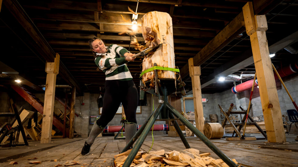 Student chopping a log with an axe