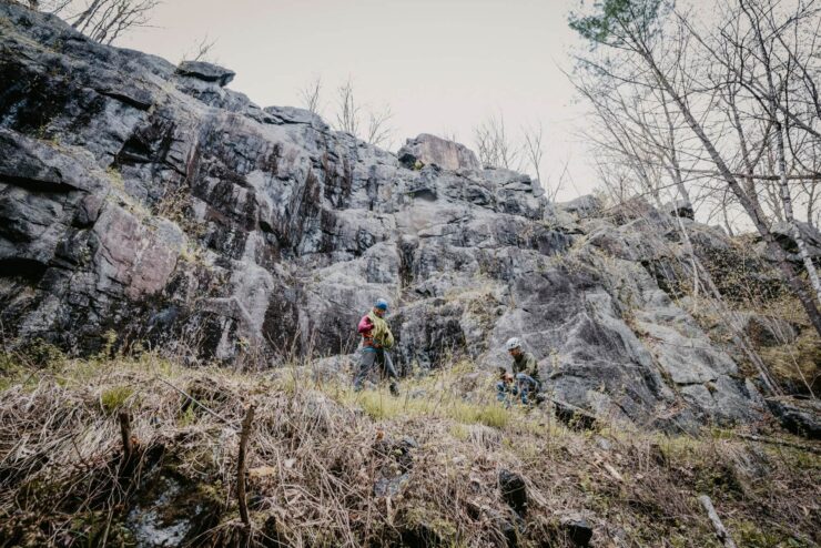 landscape of two students readying ropes to climb an ice-field rock face