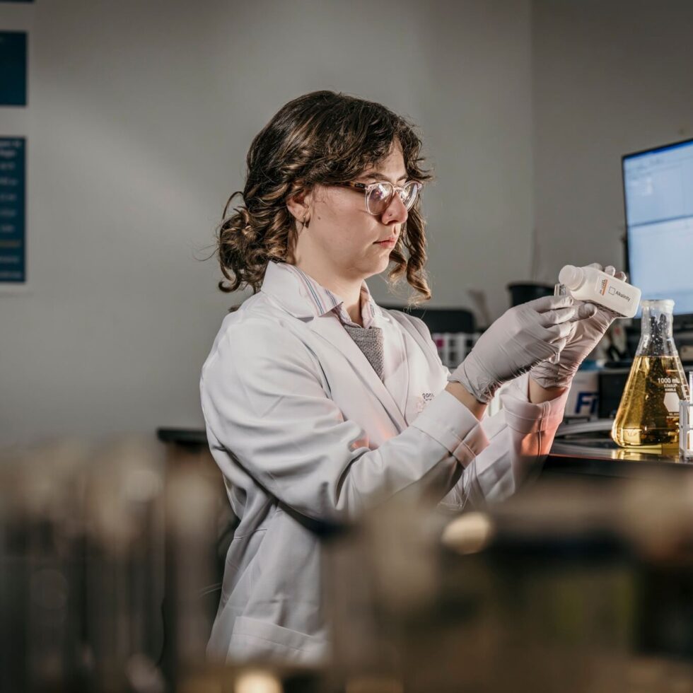 A student holding beakers in a science lab