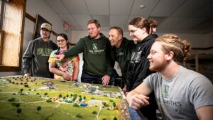 Students looking at and pointing to a diorama