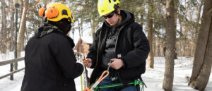 Paul Smith's professor teaching student to use climbing equipment