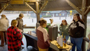 culinary students preparing and serving delicious food at gazebo lighting